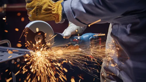 Bosch GWX18V-10P HD angle grinder in use, creating sparks while cutting metal.