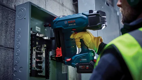 Bosch GNB18V-12 HD Biturbo Brushless tool, being used on an electrical panel by a person wearing a yellow glove. The panel has the number 223441.