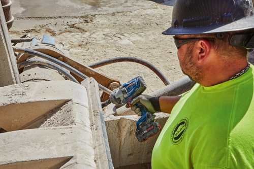 Bosch impact wrench, CORE18V 8.0Ah battery, being used by a person wearing a hard hat and gloves.