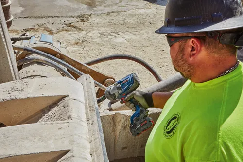 Bosch impact wrench, CORE18V 8.0Ah battery, being used by a person wearing a hard hat and gloves.