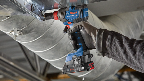 Bosch GDX18V-1800 cordless impact driver being used to tighten a screw on metal ductwork.
