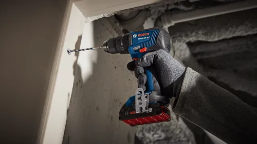 Bosch GSB18V-490 HD cordless drill being used to drill a hole.
