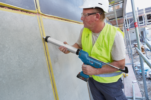 Bosch GC18V-20 sealant gun, a person wearing safety glasses, a white hard hat, and a yellow safety vest.