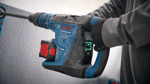 Bosch GBH18V-40C HD cordless rotary hammer, held by a person wearing a glove.