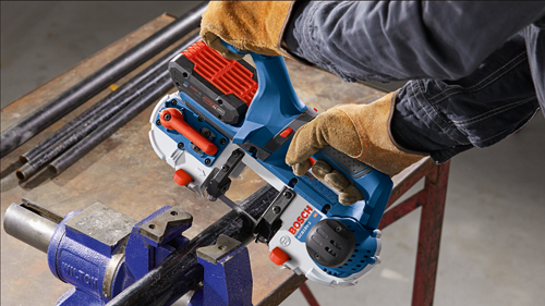 Bosch GCB18V-2 HD bandsaw cutting a metal pipe secured in a vise, with a person wearing safety gloves.