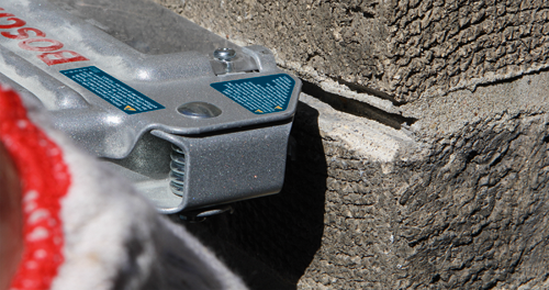 Bosch tool in contact with a rough, textured concrete surface; safety label present.