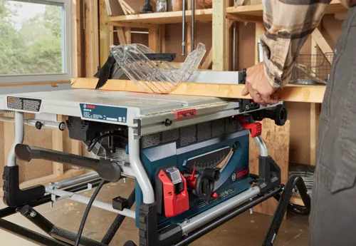 Bosch GTS15-10 table saw, with a person operating it in a workshop.