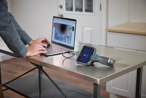 Bosch 12V 2.0 Ah tool, connected via USB cable to a laptop, displaying "Transferring files..."