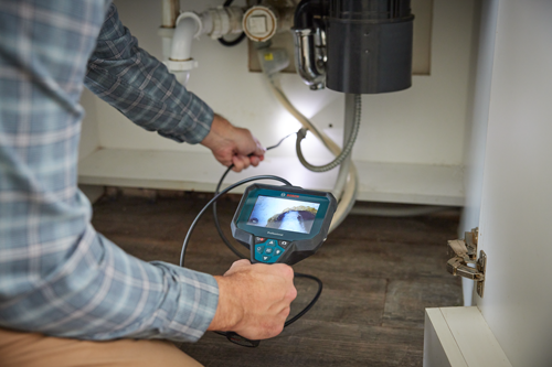 Bosch Professional inspection camera in use under a sink.
