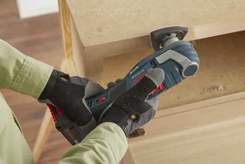 Bosch GOP18V-34 HD oscillating multi-tool, being used to cut wood.