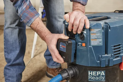 Bosch GCA30-42 component being attached to a vacuum cleaner with HEPA Ready, Automatic Filter Cleaning features and warnings label.