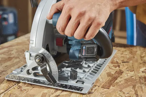Bosch circular saw on plywood, hand holding handle; visible markings include "BOSCH".