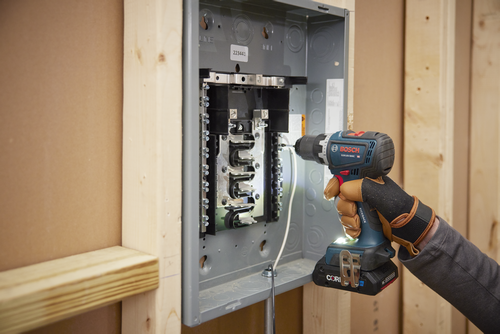 Bosch GSR18V-800C HD cordless drill being used on an electrical panel. Visible text "LINE", "223441", "KICKBACK CONTROL", "CORI", and "Ah".