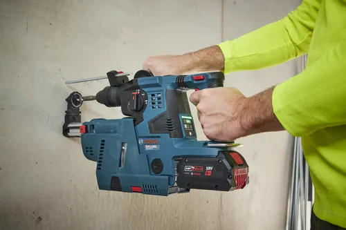 Bosch BULLDAG GBH18V-28C rotary hammer drilling into a wall, with an attached 18V 8Ah AMP Share battery.