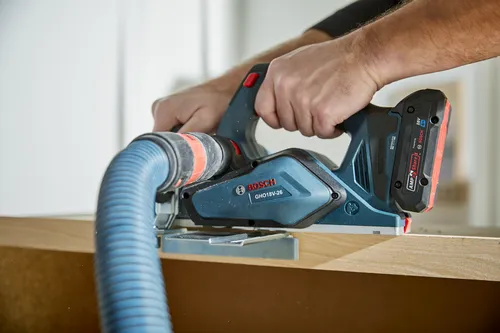 Bosch GHO18V-26 cordless planer being used by a person.