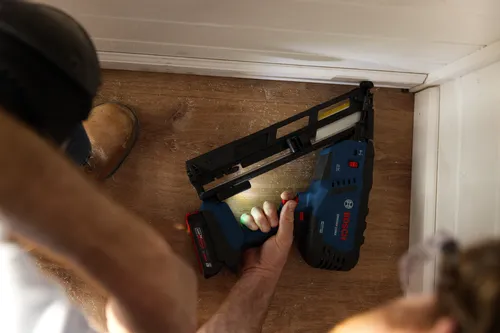 Bosch GNH18V-15MA cordless nailer being held by a person.