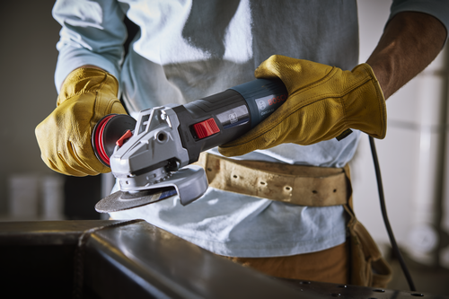 Bosch GWS14-50 angle grinder being used by a person wearing yellow gloves.