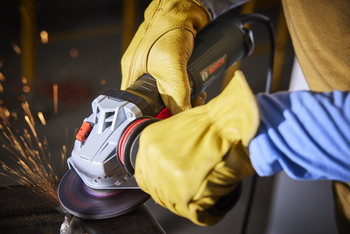 Bosch angle grinder, sparks, person wearing yellow gloves.