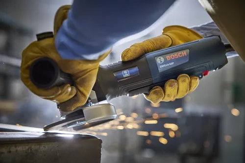Bosch GWS14-50P angle grinder cutting metal with sparks flying.