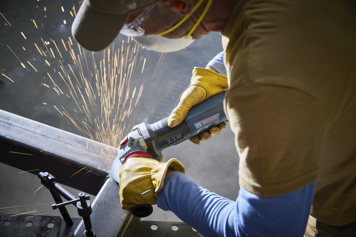 Bosch angle grinder, GW514-50PBD, is used to cut metal, sparking.