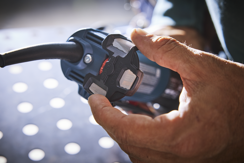 Person holding part of a black and blue power tool, with "KEEP CLEAN" and "1 II 3 / 6" visible.