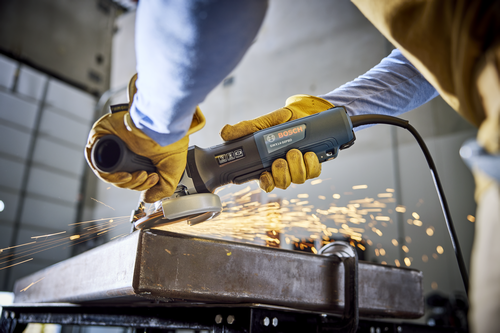 Bosch GWX14-50PBD angle grinder in use, with sparks flying from the metal being ground.