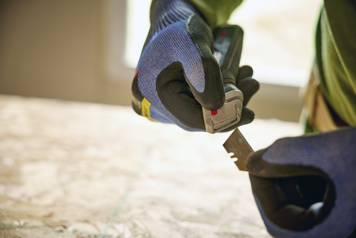 A person using the Bosch H11-13000-1 Retractable knife replacing the blade.