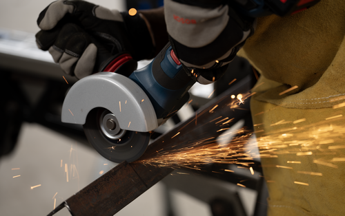The Bosch GWS18V-11PS 18V Brushless 4-1/2 – 5 In. Angle Grinder with No Lock-On Paddle Switch in use for cutting a steel bar.