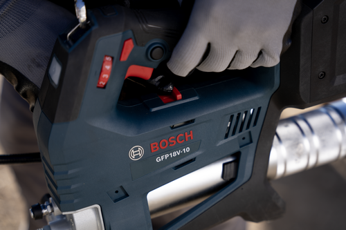A worker using the Bosch GFP18V-10 18V Grease Gun on a close-up visualization.