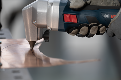 The worker using the GNA18V-16E 18V 16-Gauge Nibbler With Lock-On Slide Switch to cutting a copper plate.