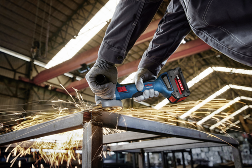 Worker using the Bosch GWX18V-8-2N 18V X-LOCK 4-1/2 In. Angle Grinder for cutting a steel plate.