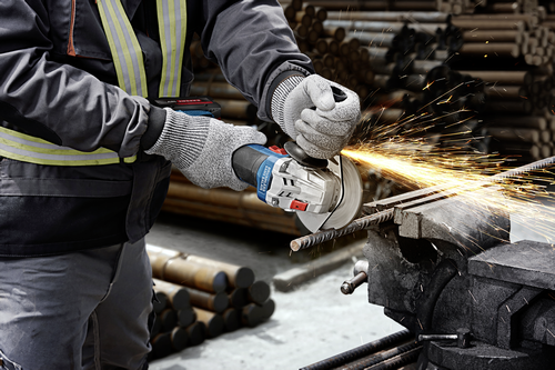 Worker using the Bosch GWX18V-8-2N 18V X-LOCK 4-1/2 In. Angle Grinder for cutting a steel rebar.