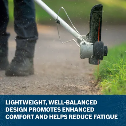 Close-up image of worker using the Bosch GRT18V-40N 18V Brushless String Trimmer to mow the grass in a backyard.