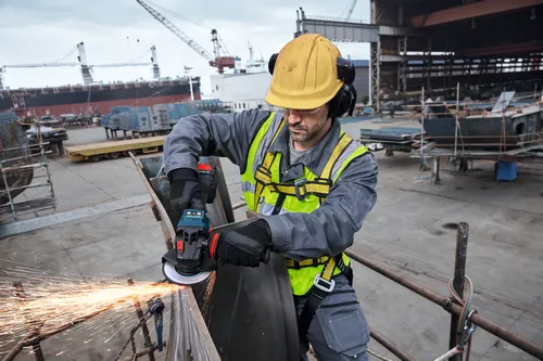 Worker grinding a metal with Bosch EXWS18V-15S 18V Brushless 6 In. Angle Grinder with No Lock-On Paddle Switch.