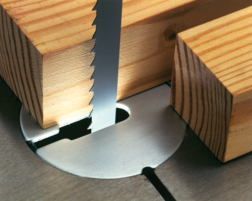 Band saw blade cutting through wood.