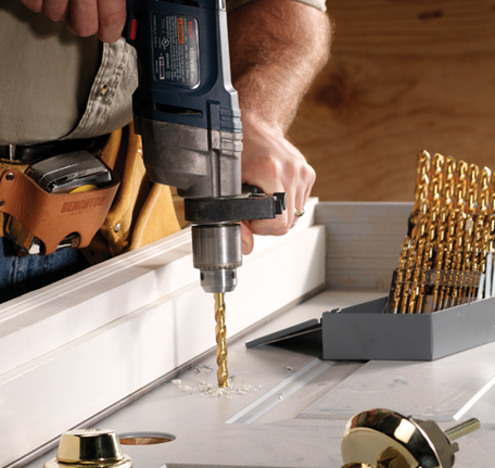 Bosch titanium nitride coated drill bit drilling in a door.