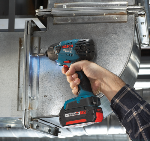 Destornillador de impacto Bosch Lithion 18V siendo utilizado para trabajar en conductos metálicos. La herramienta es sostenida por una persona que lleva una camisa a cuadros.