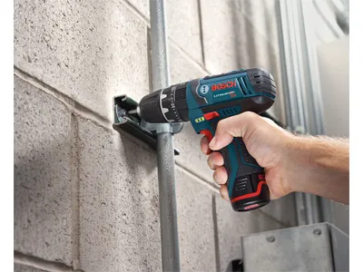 Taladro Bosch de 12V con batería de iones de litio utilizado para fijar un soporte a una pared de ladrillo.