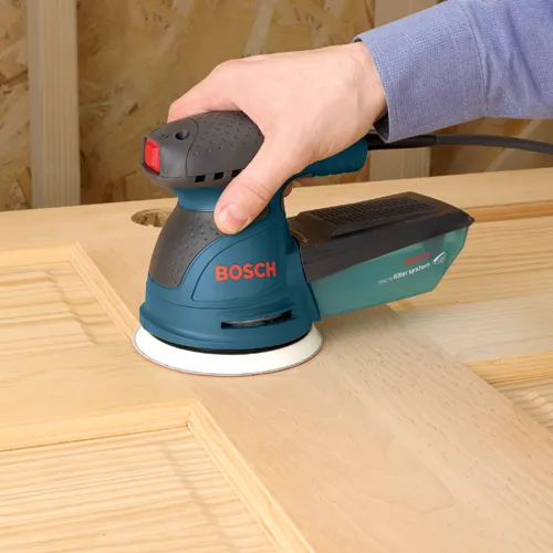 Lijadora Bosch sobre superficie de madera con "BOSCH" visible, "microfiltersystem" visible.