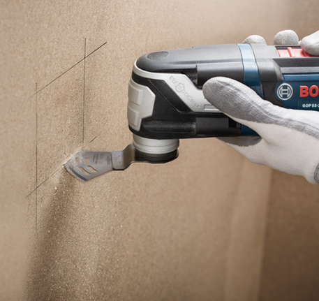 Bosch GOP 55-36 herramienta multifunción oscilante cortando una superficie de madera.