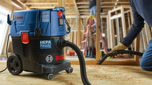 Aspiradora Bosch VAC090A HEPA Ready en uso por una persona que lleva un guante de trabajo.