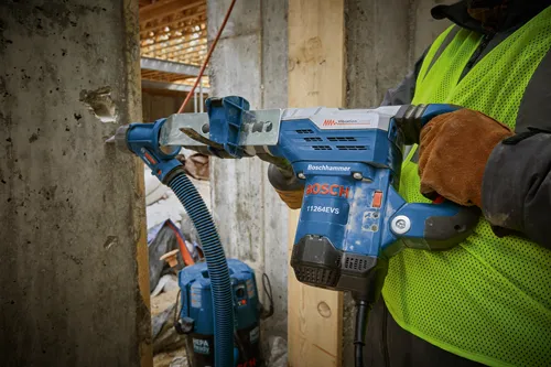 Taladro percutor Boschhammer 11264EVS en uso por una persona que lleva un chaleco de alta visibilidad.