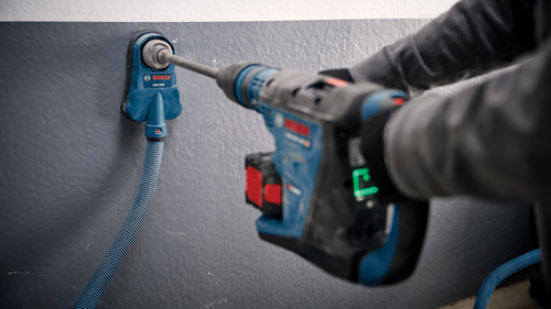 Bosch HDC200, taladro y aspirador de polvo en uso por una persona.