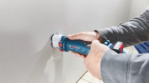 Persona utilizando una herramienta de corte Bosch GCU18V-30 en paneles de yeso.