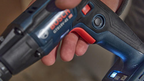 Destornillador a batería BOSCH GTB18V-45 en manos de una persona; las características visibles incluyen un botón de encendido/apagado y una luz en pantalla.