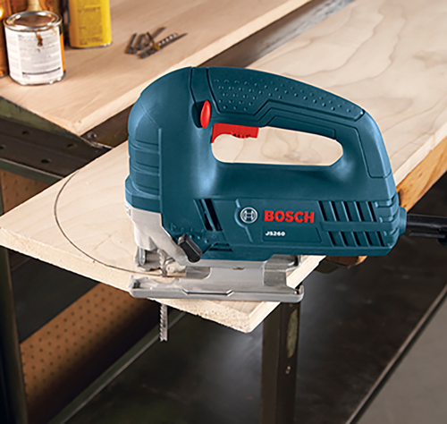 Sierra caladora Bosch JS260 cortando una línea curva en madera.