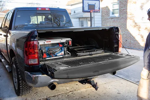 Caja de camión abierta con una sierra de mesa BITURBO Bosch y otras herramientas.