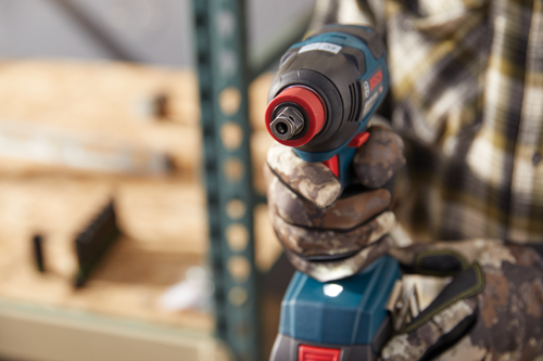 Llave de impacto Bosch sostenida por una persona que lleva guantes de camuflaje.