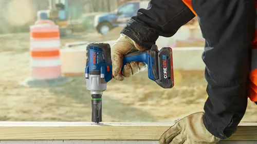 Bosch GDS18V-330C, CORE18V 4 Ah, llave de impacto, siendo utilizada en una pieza de madera.