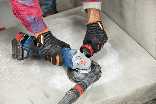 Bosch 18V AMP Share amoladora angular inalámbrica con accesorio de cepillo, sostenida por una persona que lleva guantes de protección.